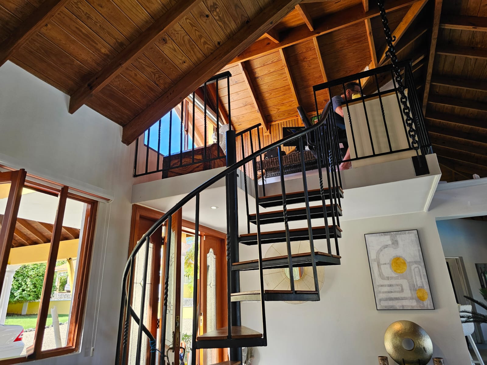 buyDRproperty Interior view of a luxury villa with a spiral staircase leading to a loft area with ocean views. Sosua Real Estate
