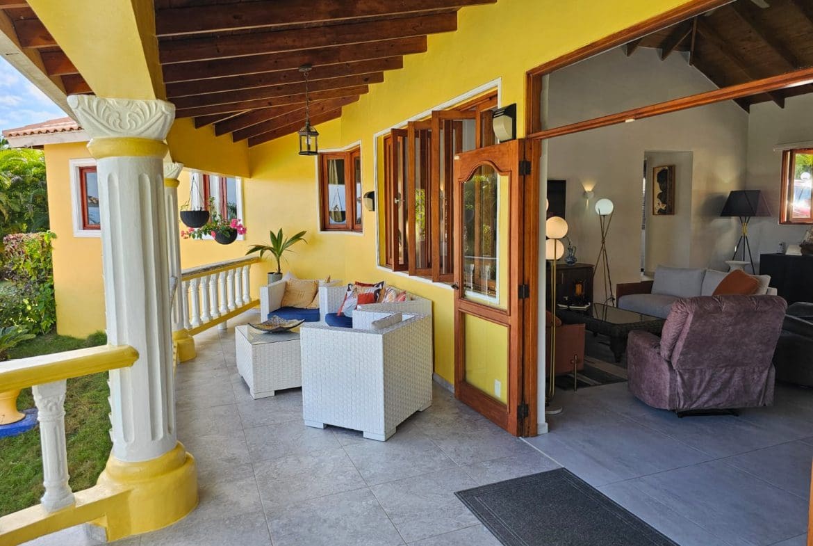 buyDRproperty Villa for sale with ocean views: covered patio with seating and open doorway. Sosua Real Estate