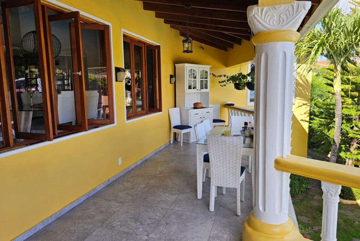 buyDRproperty Covered patio with dining set and ocean views at a luxury villa for sale. Sosua Real Estate
