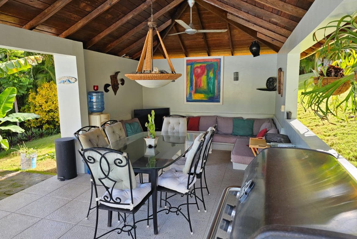 buyDRproperty Outdoor dining area with a grill, table and seating, and a lounge area in a luxury villa with ocean views for sale. Sosua Real Estate