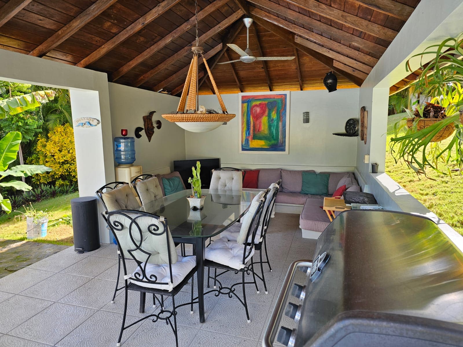 buyDRproperty Outdoor dining area with a grill, table and seating, and a lounge area in a luxury villa with ocean views for sale. Sosua Real Estate