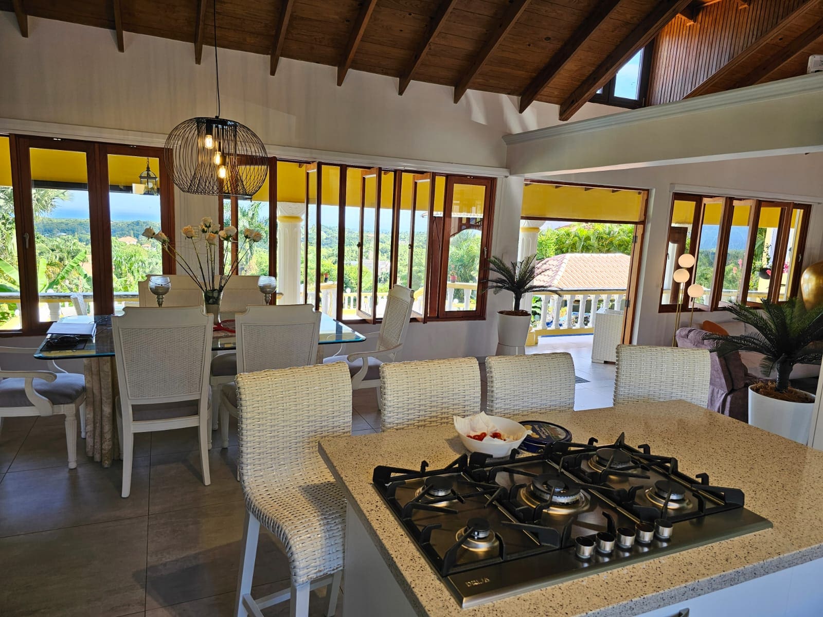 buyDRproperty Bright villa interior with dining area, kitchen island, and amazing ocean views. Villa for sale. Sosua Real Estate