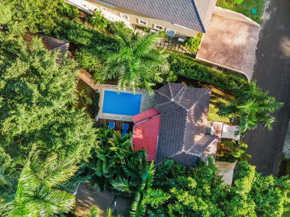 buyDRproperty Aerial view of a 1 Bedroom Villa with a pool and lush tropical landscaping. Sosua Real Estate