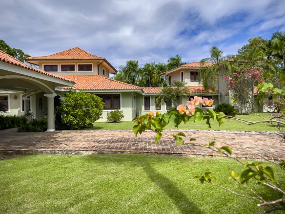 buyDRproperty 4-Bedroom Villa for sale in Sea Horse Ranch: Exterior view of a green villa with a red tile roof. Sosua Real Estate