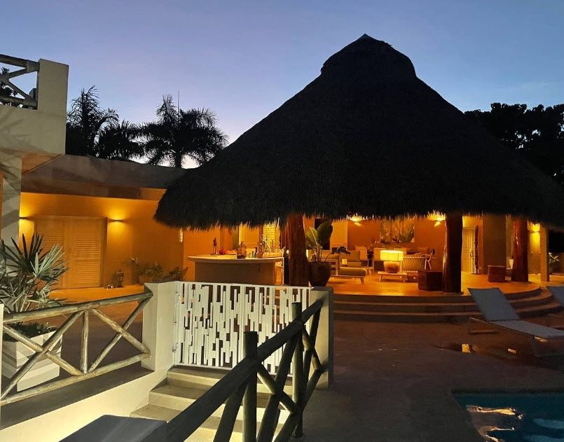 buyDRproperty Night view of an Ocean View Villa for Sale in Cabrera, Dominican Republic. Luxury home with thatched roof. Sosua Real Estate