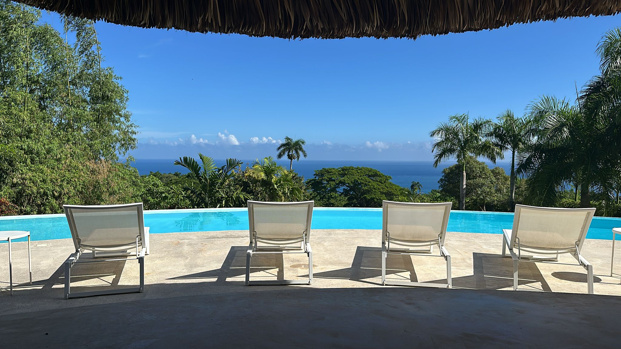 buyDRproperty Ocean view from villa for sale in Cabrera, Dominican Republic. Lounge chairs by the pool overlooking the ocean. Sosua Real Estate