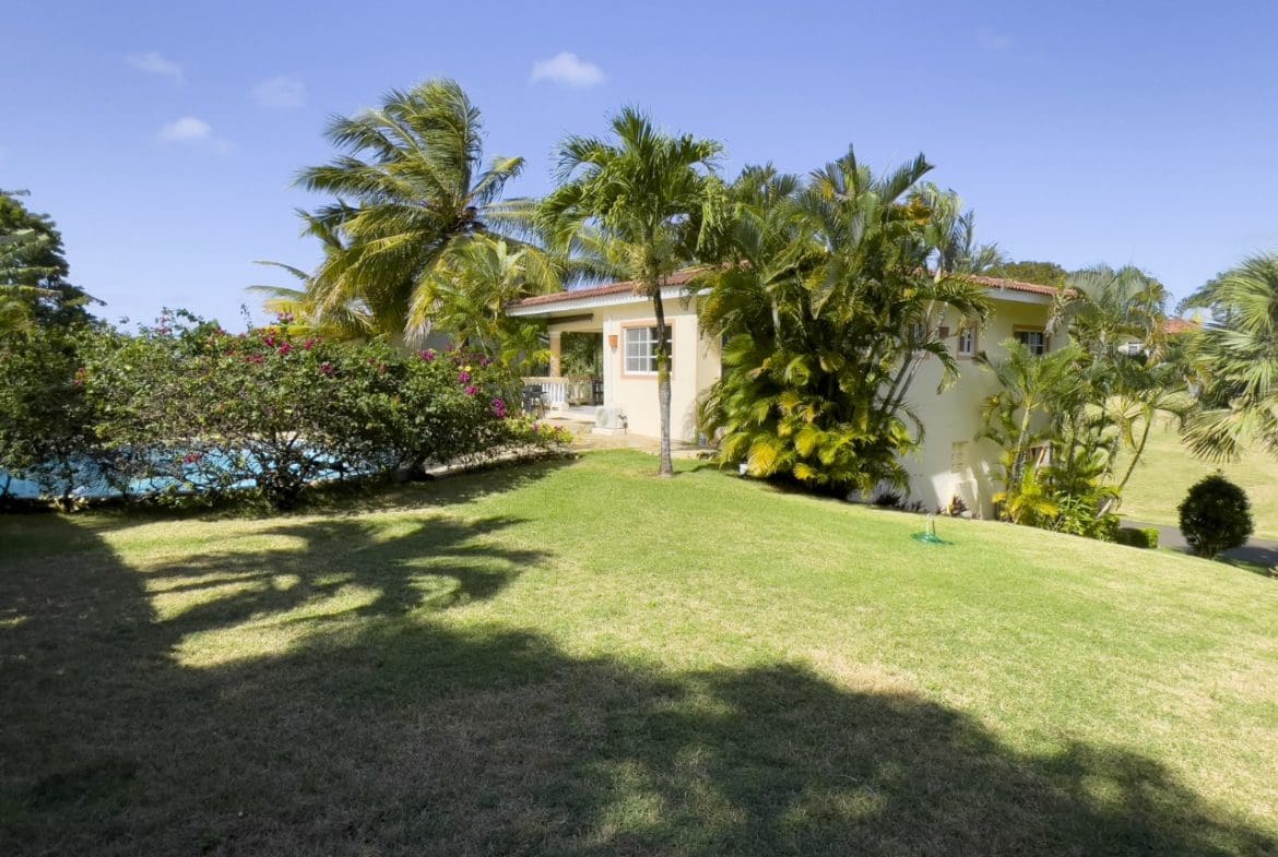 buyDRproperty Lush lawn and tropical plants surround a 3BR Ocean View Home in Hispaniola. Sosua Real Estate