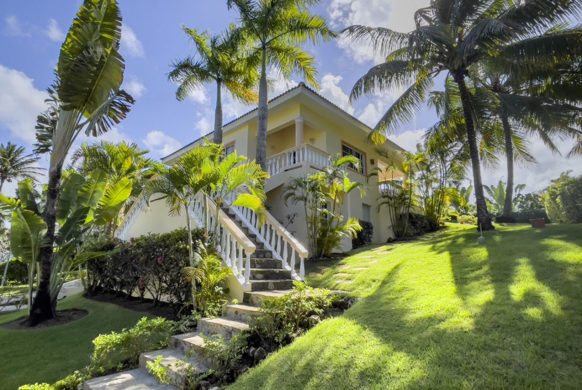 buyDRproperty 3BR Ocean View Home in Hispaniola with lush landscaping and a staircase leading to a balcony. Sosua Real Estate
