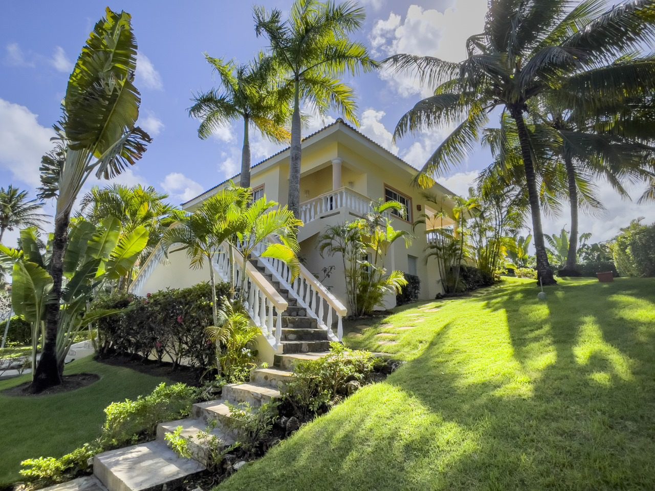 buyDRproperty Charming 3BR Ocean View Home in Sosua, Hispaniola, with palm trees and steps leading to the entrance. Sosua Real Estate