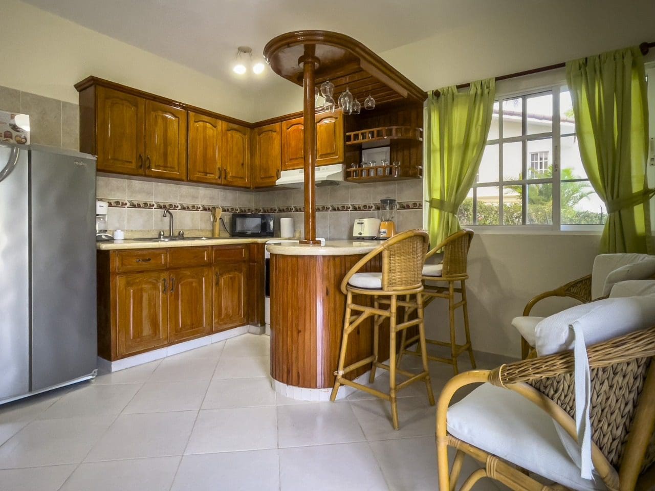 buyDRproperty Kitchen in 3BR Ocean View Home, Hispaniola, with wooden cabinets and bar seating. Sosua Real Estate