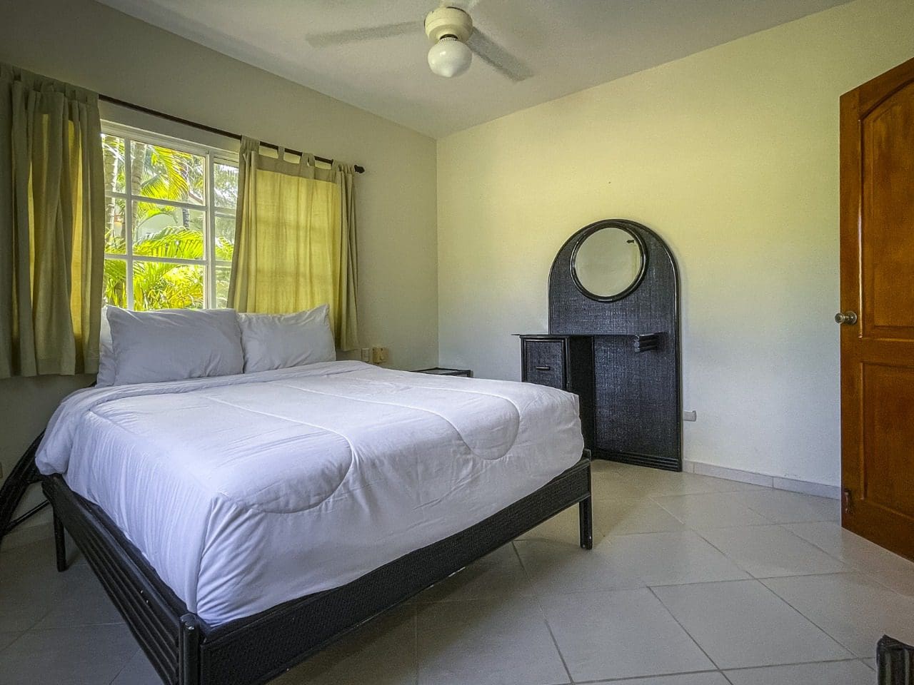 buyDRproperty Bedroom interior featuring a bed, dresser with mirror, and window in this 3BR Ocean View Home. Sosua Real Estate