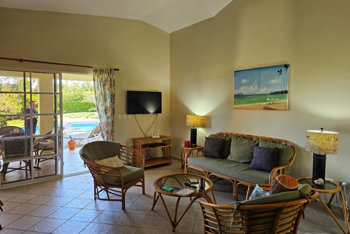 buyDRproperty Living room with rattan furniture and pool view in a 3 Bedroom Villa For Sale Sosua Real Estate