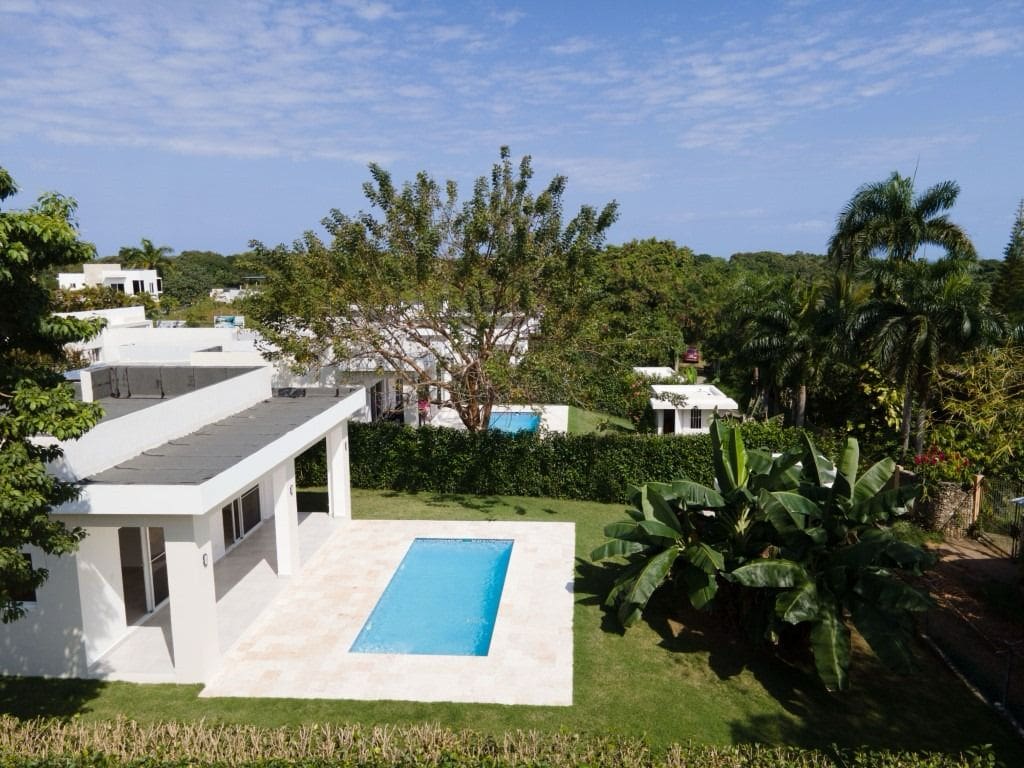 buyDRproperty Home for sale in Sosua: modern white house with a pool and tropical landscaping. Sosua Real Estate