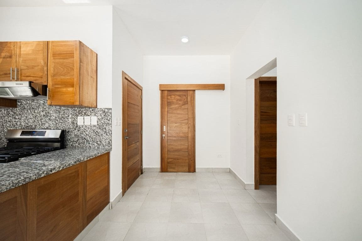 buyDRproperty Kitchen and hallway in a home for sale with wooden doors and cabinets. Sosua Real Estate