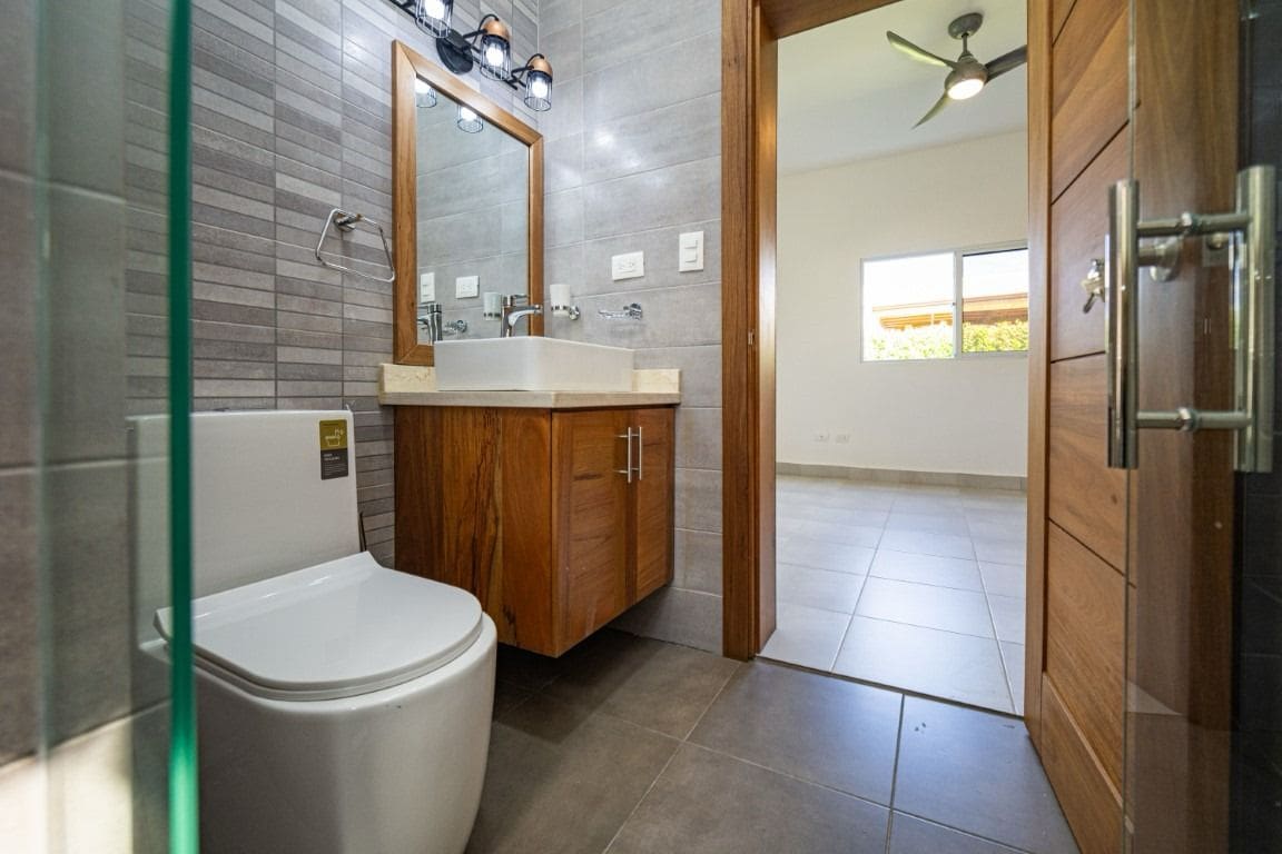 buyDRproperty Bathroom with wooden vanity and a view of a home for sale. Sosua Real Estate