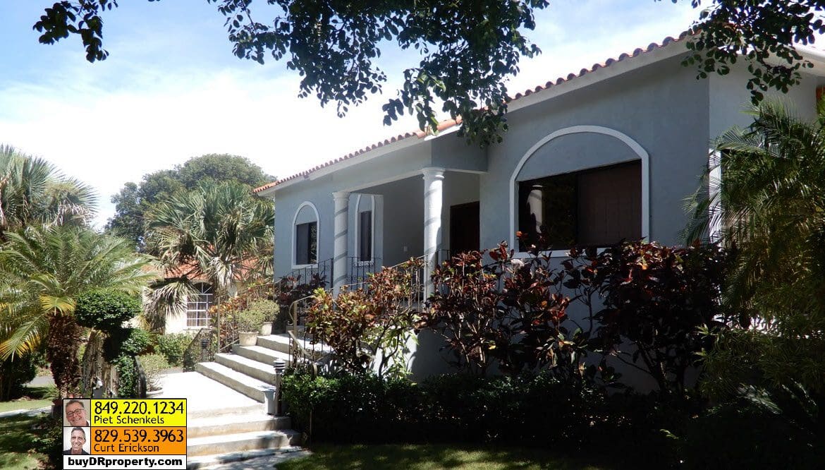buyDRproperty Casa Linda villa exterior with lush landscaping and steps leading to the entrance. Sosua Real Estate