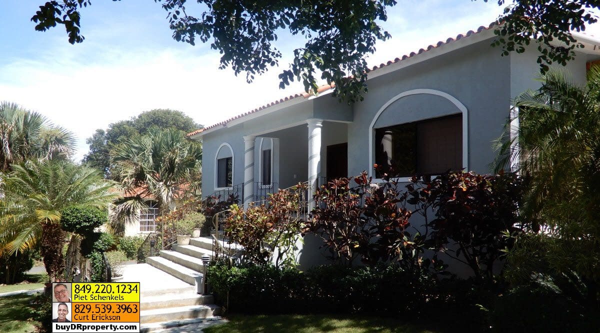 buyDRproperty Casa Linda villa exterior with lush landscaping and steps leading to the entrance. Sosua Real Estate