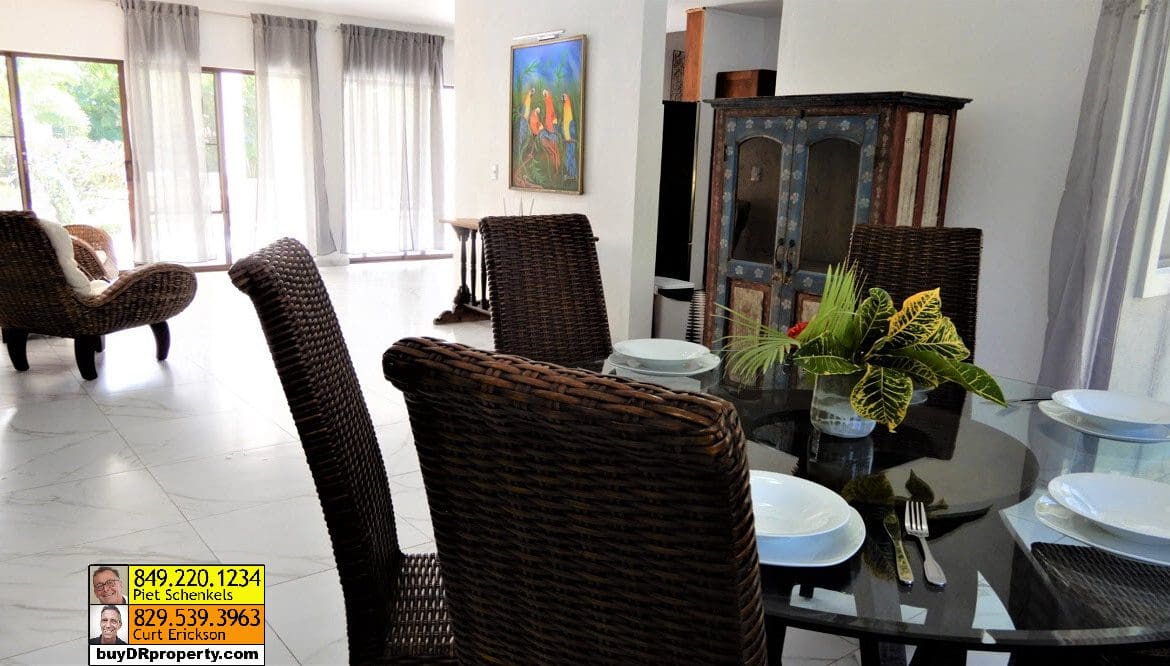 buyDRproperty Dining area in a Casa Linda villa for sale with woven chairs and a glass table. Sosua Real Estate