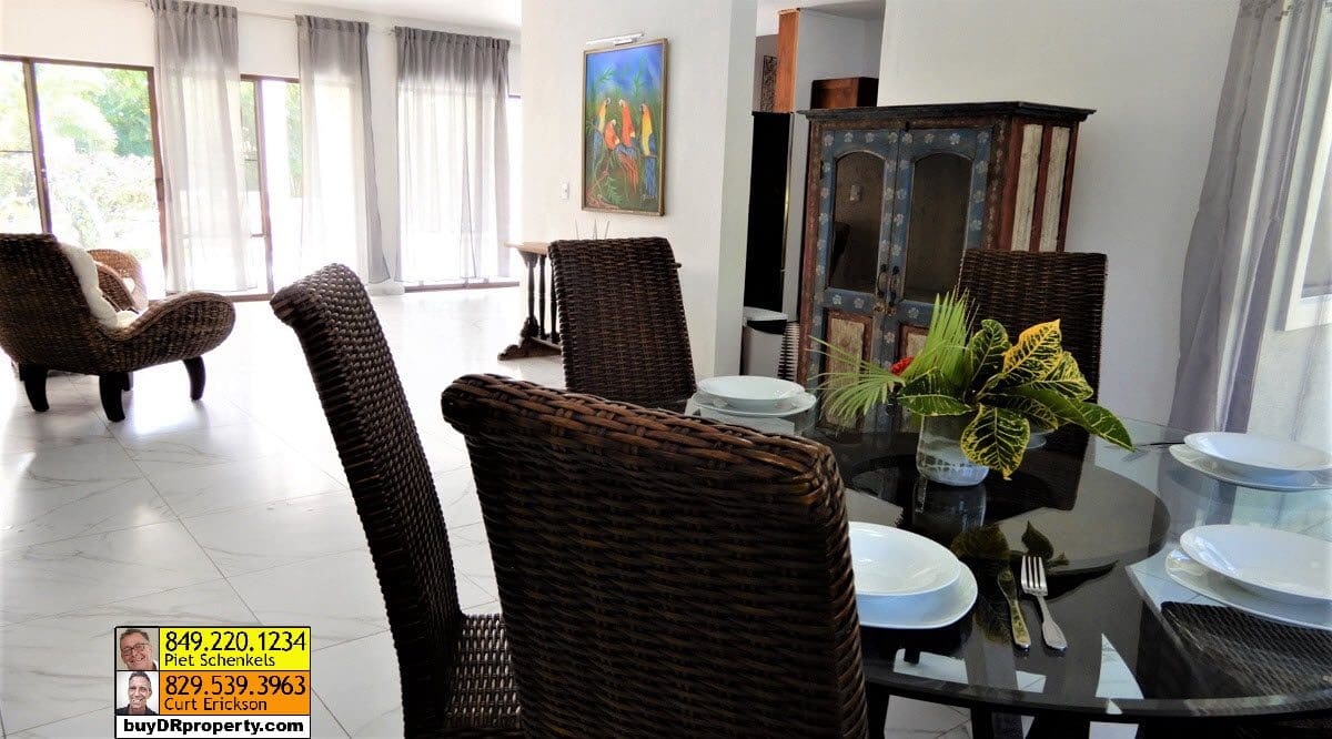 buyDRproperty Dining area in a Casa Linda villa for sale with woven chairs and a glass table. Sosua Real Estate