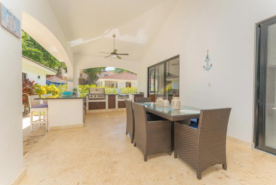 buyDRproperty Outdoor dining area at a villa in Hispaniola Residential with a grill and ocean decor. Sosua Real Estate