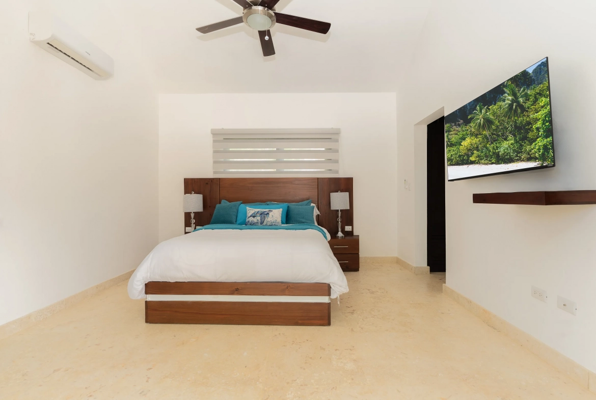 buyDRproperty Modern bedroom in a villa, with a bed, TV, and ceiling fan. Sosua Real Estate