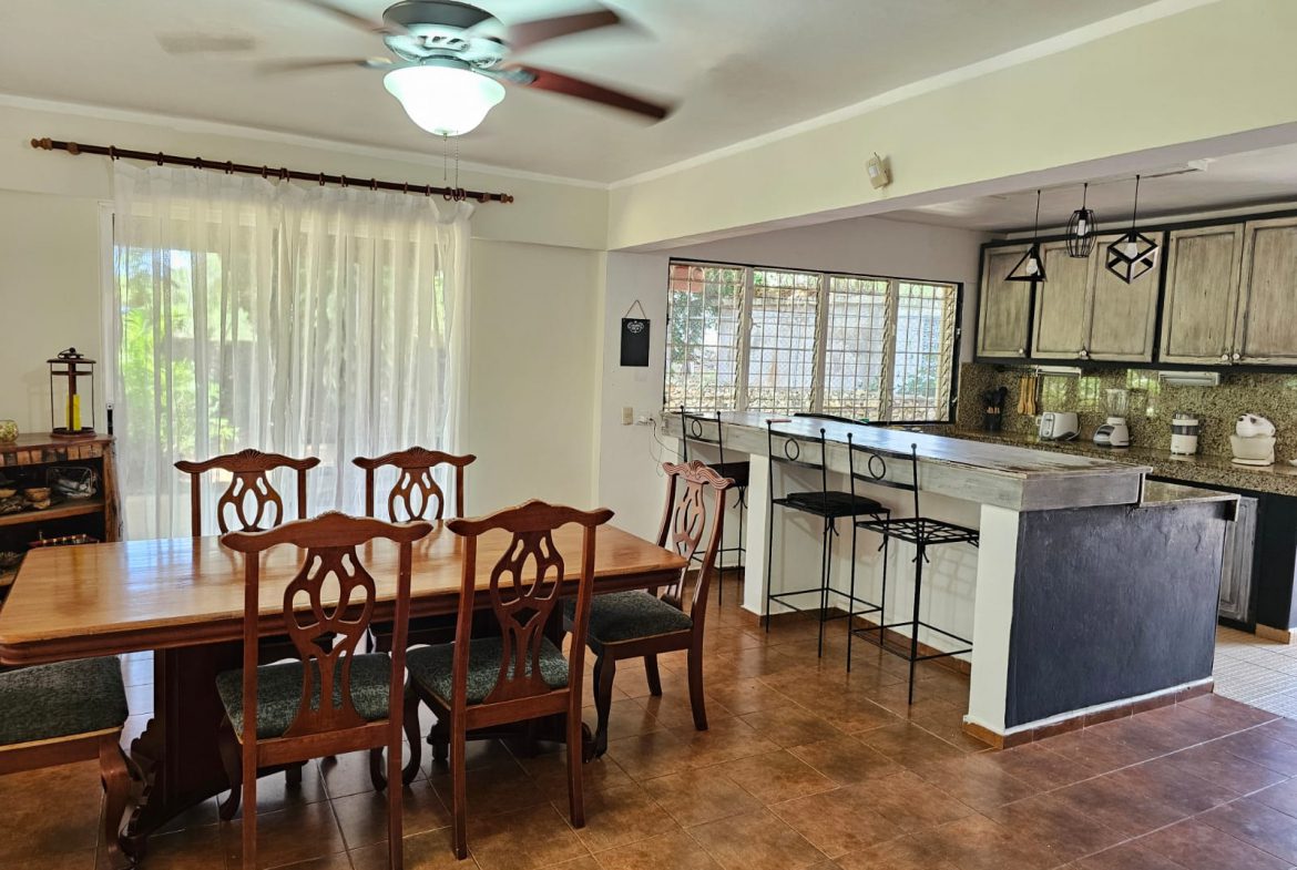 buyDRproperty Dining area and kitchen in a unique Sosua villa with a ceiling fan and breakfast bar. Sosua Real Estate