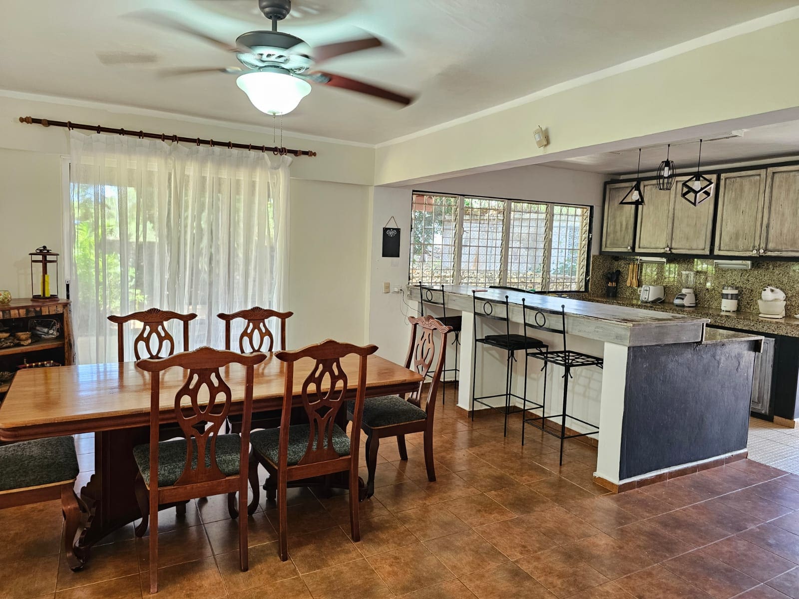 buyDRproperty Dining area and kitchen in a unique Sosua villa with a ceiling fan and breakfast bar. Sosua Real Estate