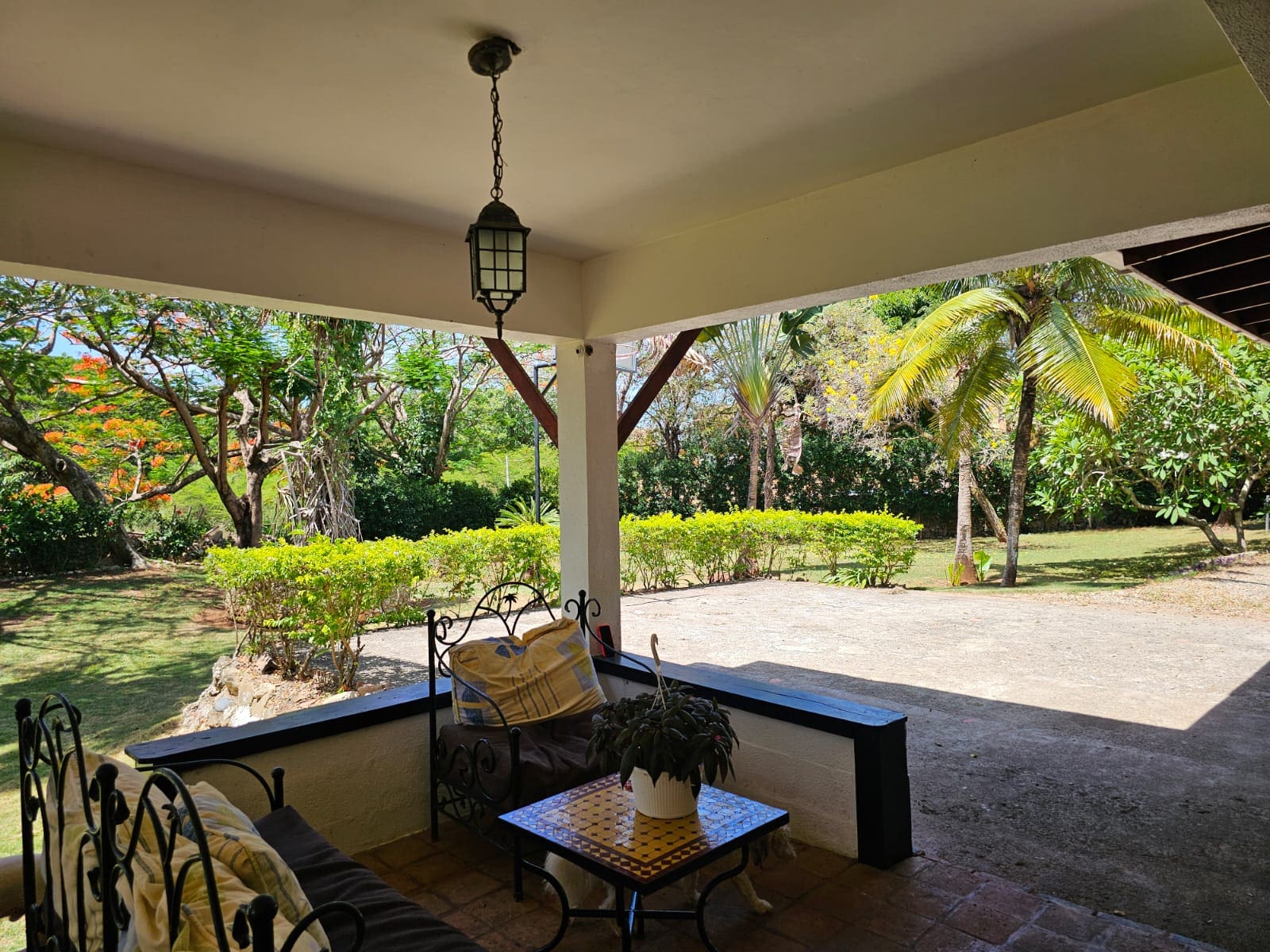 buyDRproperty Covered porch with seating at a unique Sosua villa overlooking lush tropical gardens. Sosua Real Estate