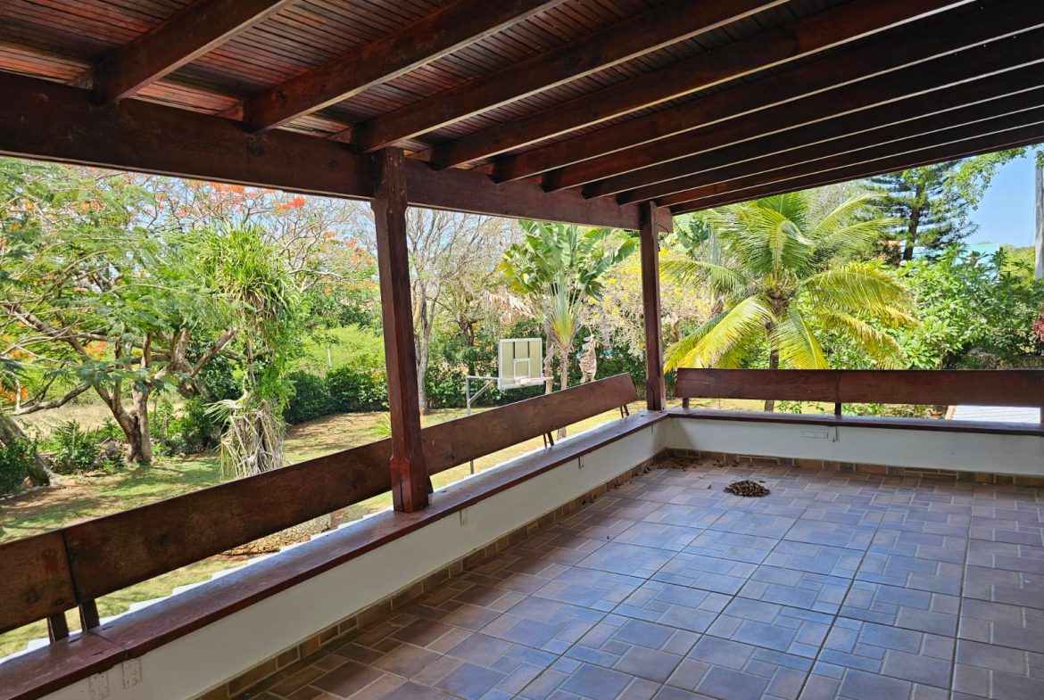 buyDRproperty Sosua villa balcony with wooden beams and lush garden view. Unique property. Sosua Real Estate
