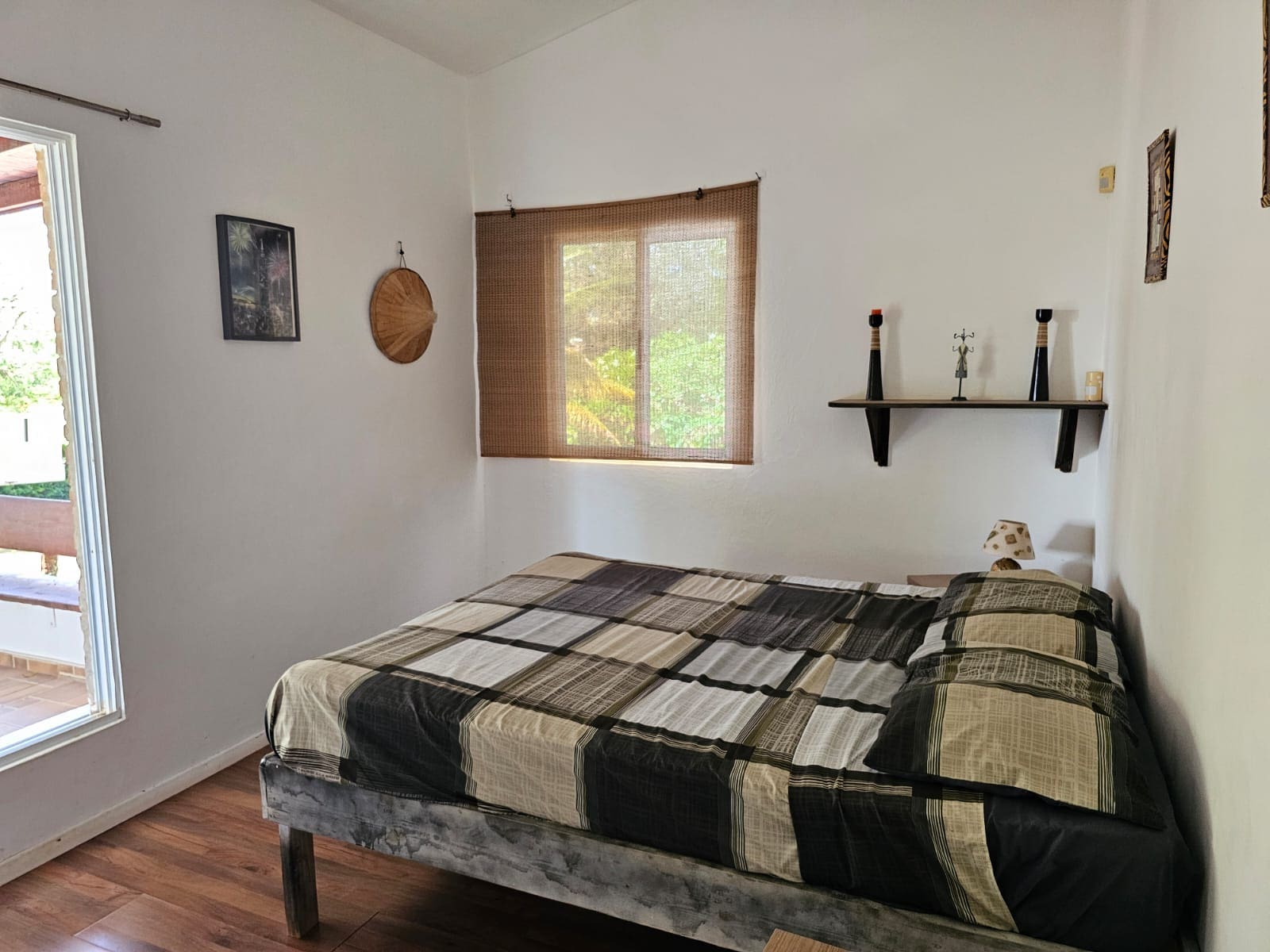buyDRproperty Bedroom in a unique Sosua villa with a bed, window, and simple decor. Sosua Real Estate