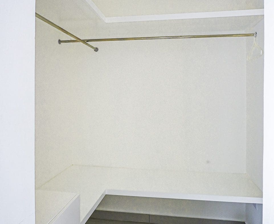 buyDRproperty Modern walk-in closet with white walls and a hanging rod. Sosua Real Estate