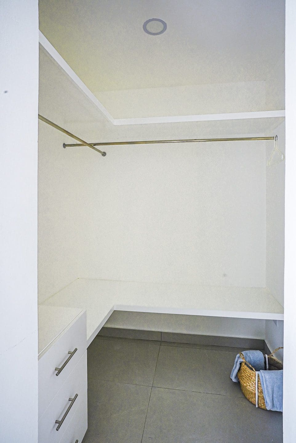 buyDRproperty Modern walk-in closet with white walls and a hanging rod. Sosua Real Estate