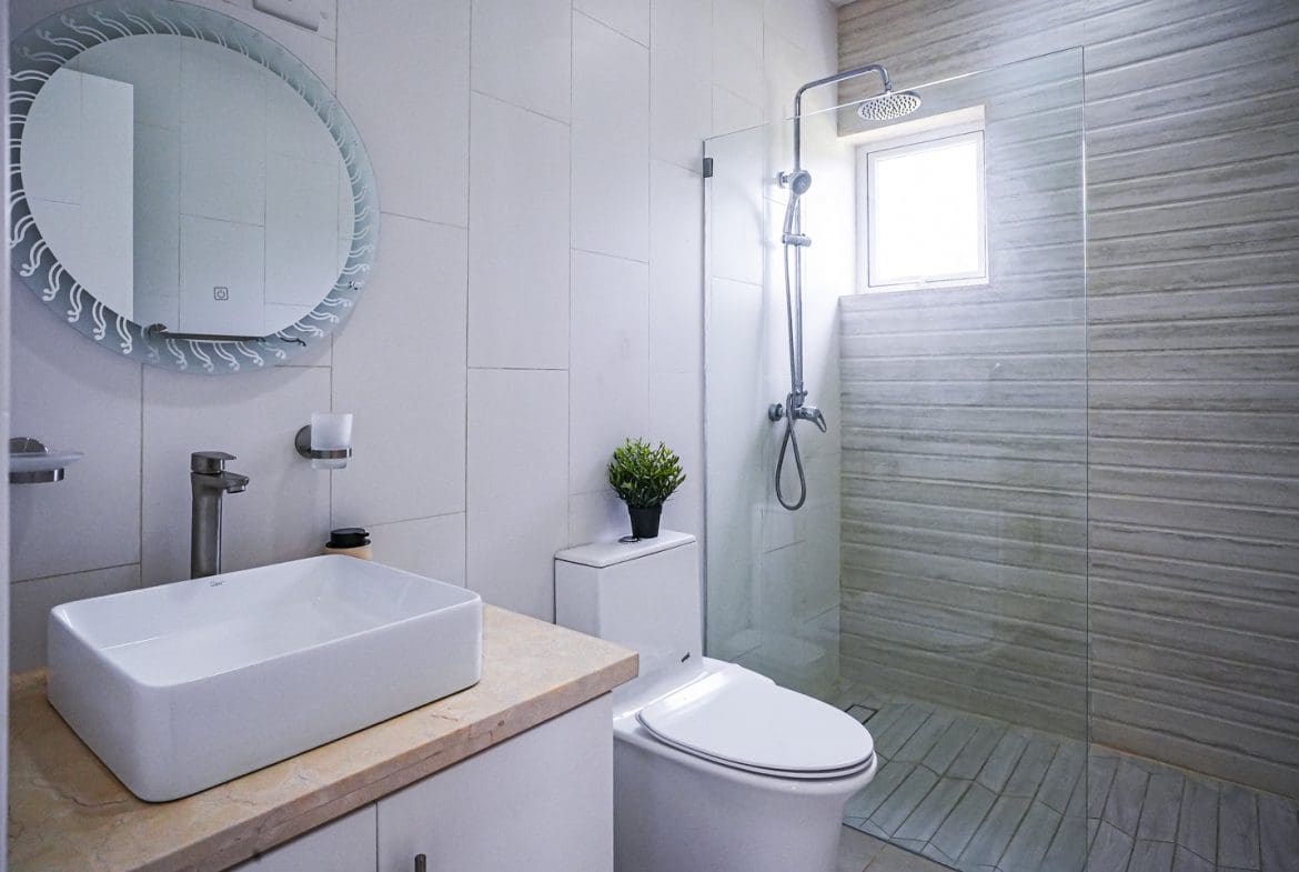 buyDRproperty Modern bathroom in a villa with a glass shower and white fixtures. Sosua Real Estate