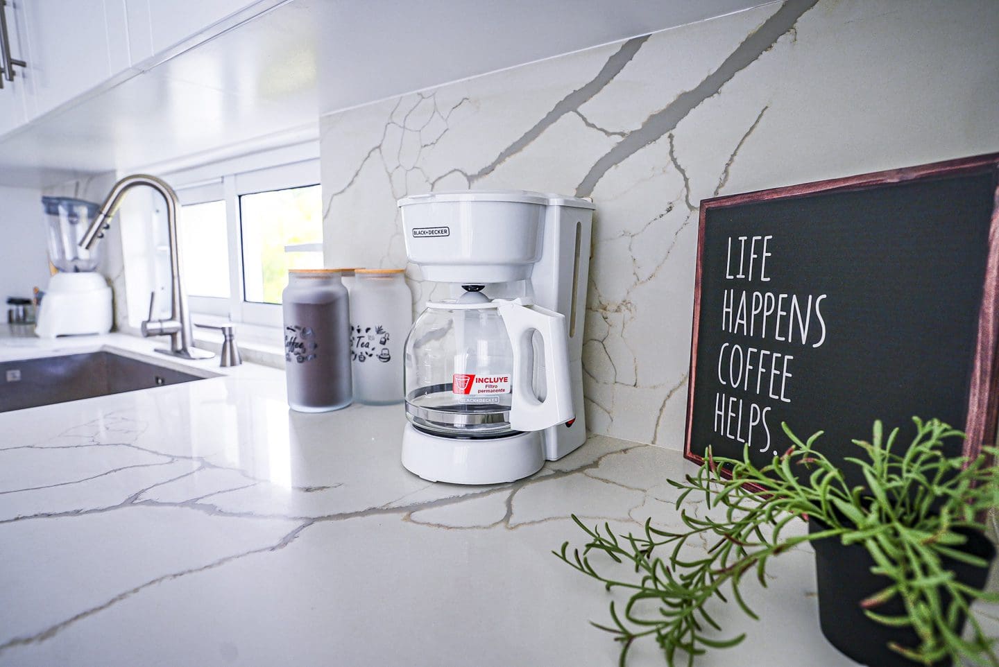 buyDRproperty Modern kitchen countertop with coffee maker and "Life Happens Coffee Helps" sign. Sosua Real Estate