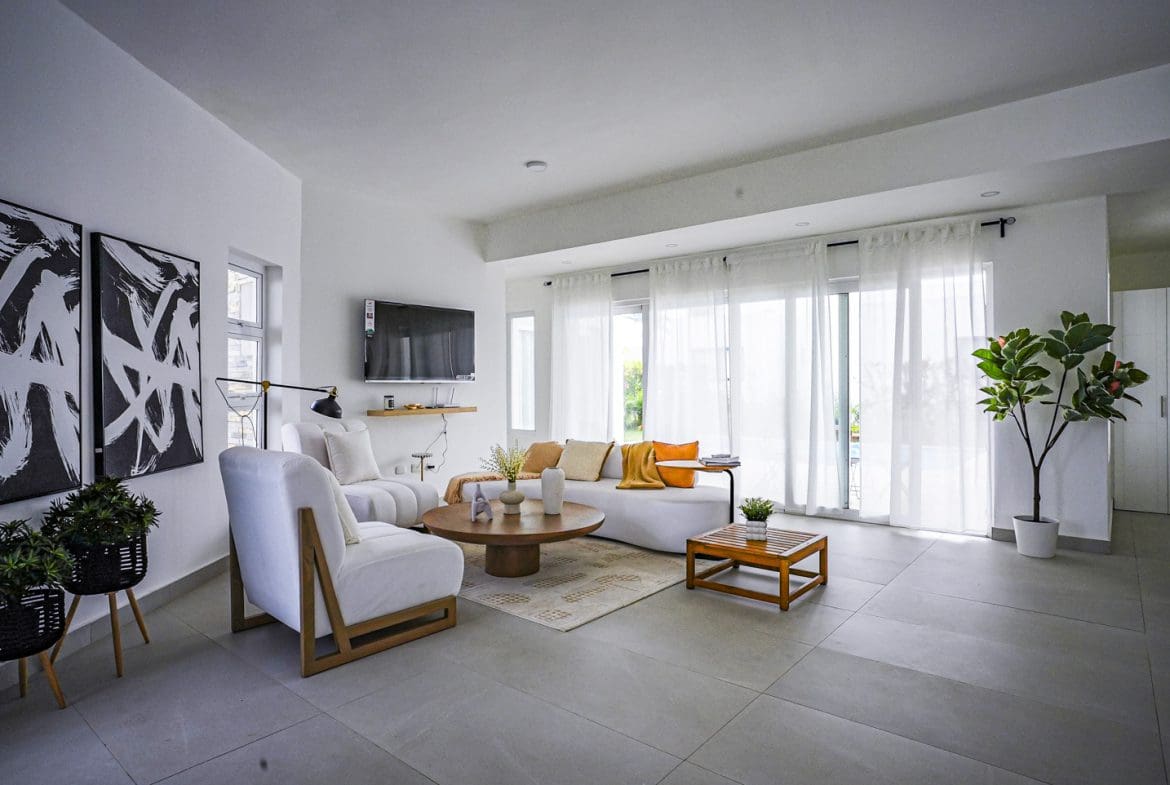 buyDRproperty Modern living room in a 3 BR villa, featuring a white sofa and abstract art. Sosua Real Estate