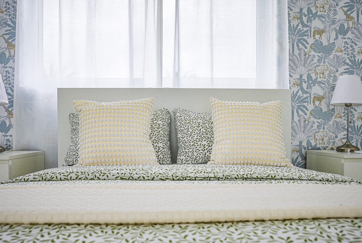 buyDRproperty Modern bedroom with patterned pillows and wallpaper Sosua Real Estate