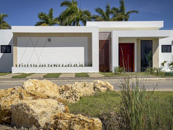 buyDRproperty Modern white villa with red door and wooden accents in Sosua Ocean Village. Sosua Real Estate