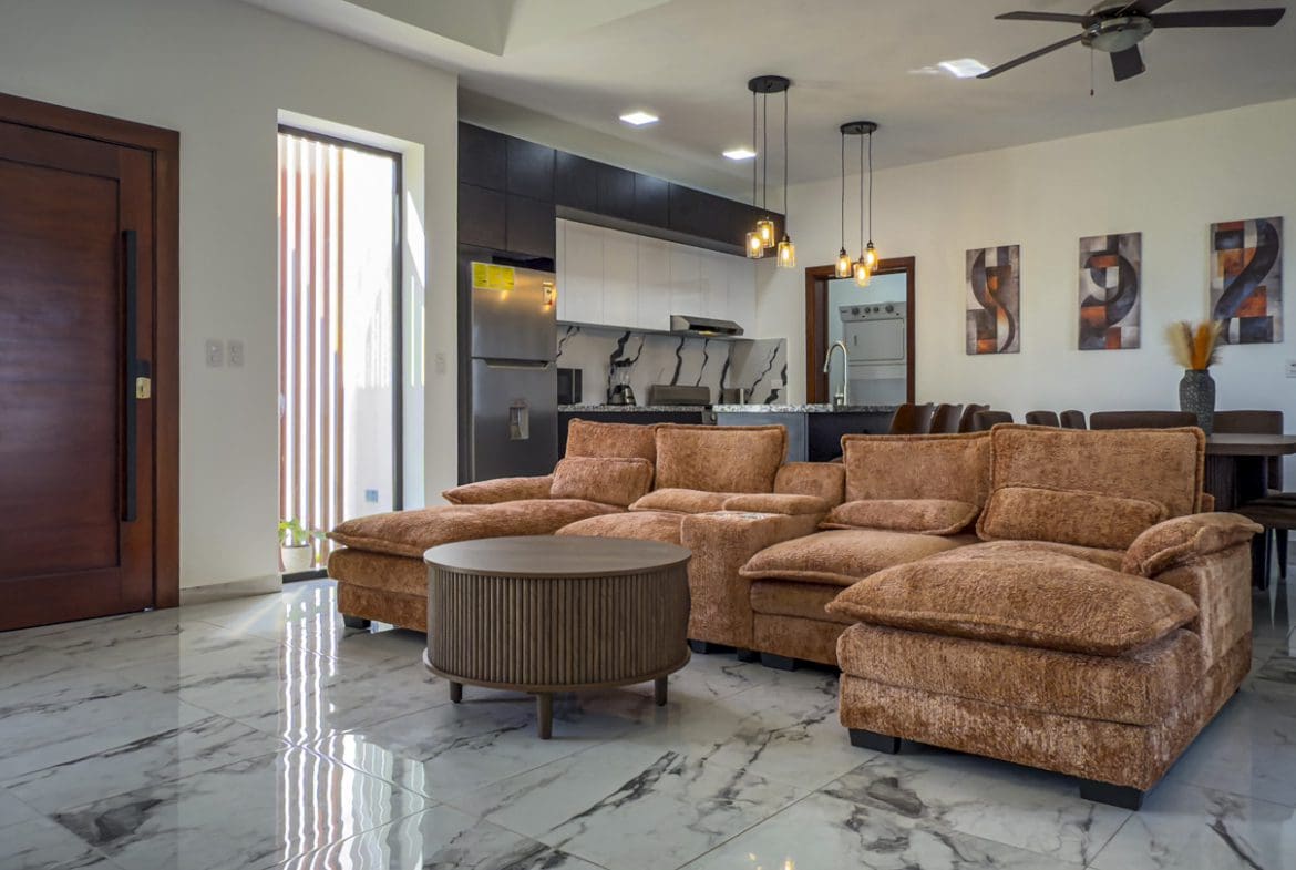 buyDRproperty Modern living room in 3BR Villa Sosua Ocean Village with kitchen, seating and dining area. Sosua Real Estate