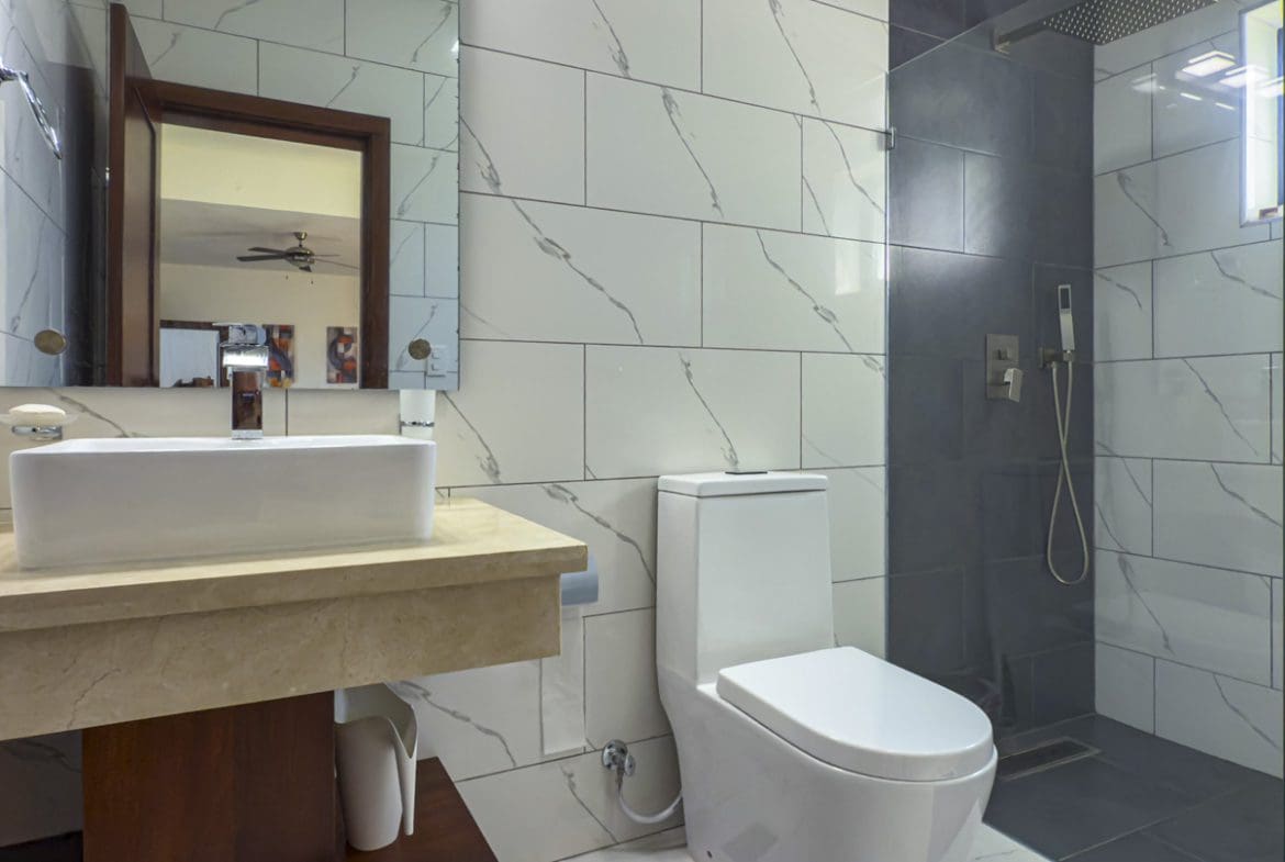 buyDRproperty Modern bathroom in a Sosua Ocean Village villa with marble-look tiles and walk-in shower. Sosua Real Estate