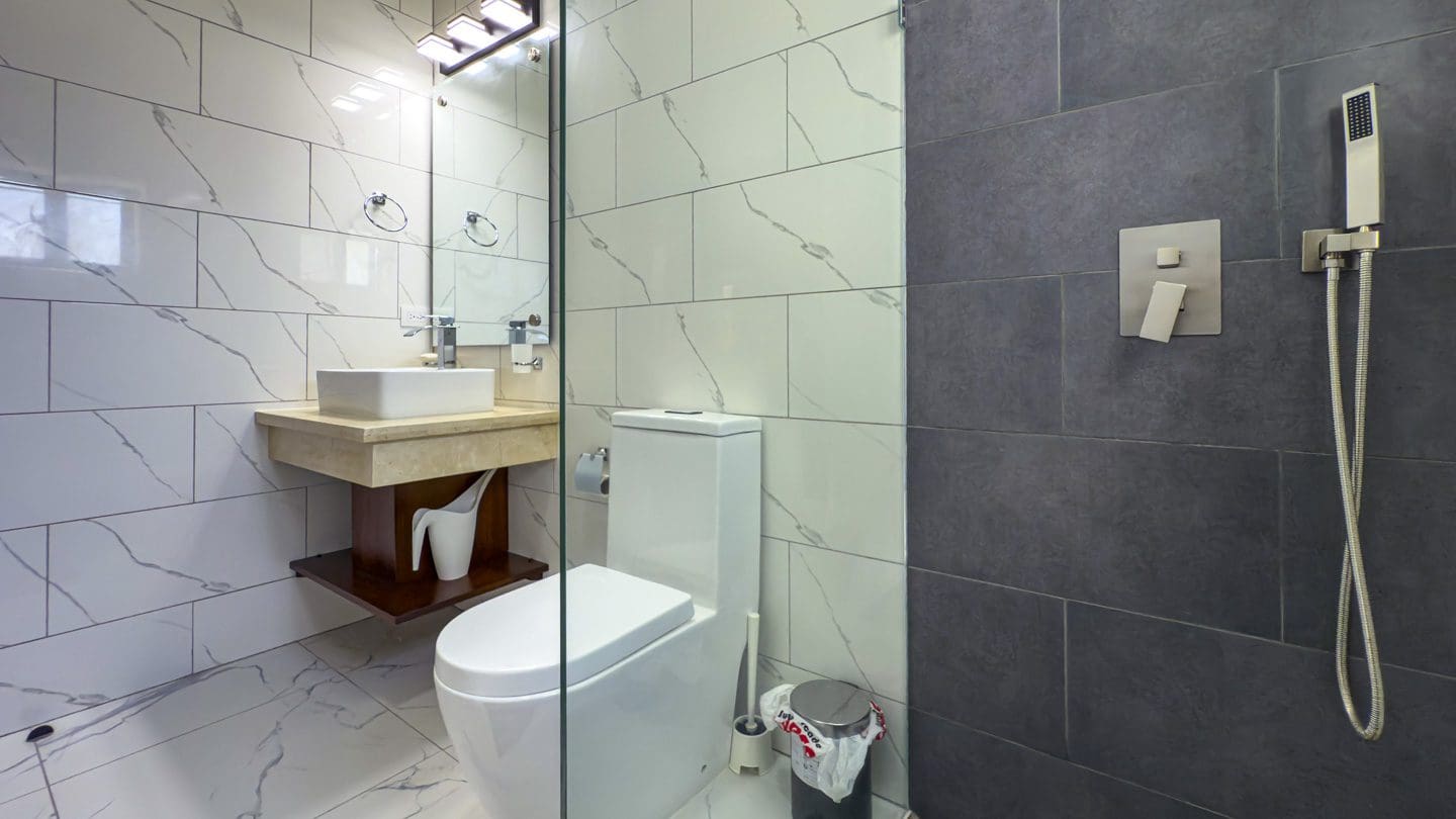 buyDRproperty Modern bathroom with marble tile, floating vanity, and walk-in shower. Sosua Real Estate