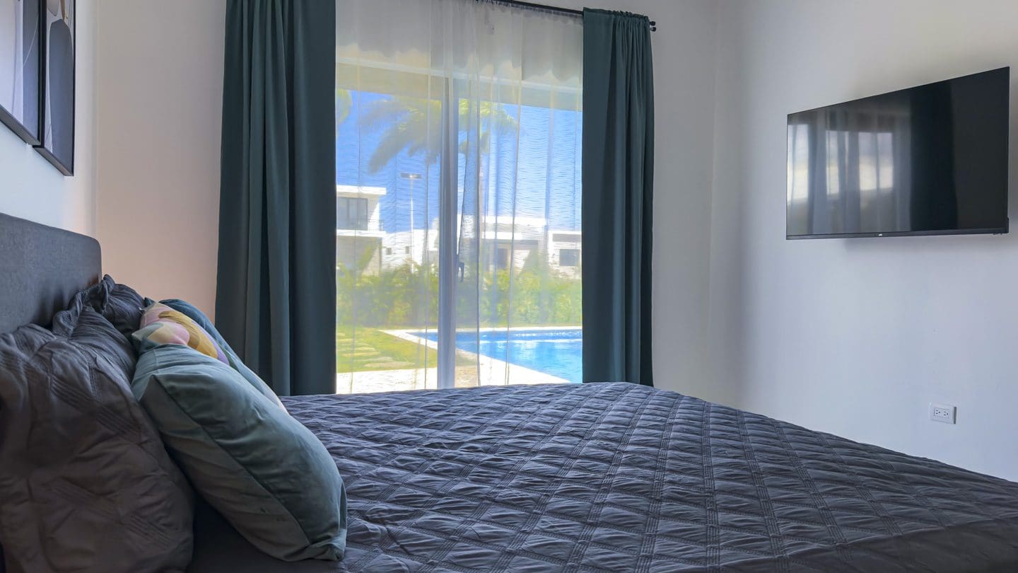 buyDRproperty Bedroom with a view of a pool in a modern villa. Sosua Real Estate