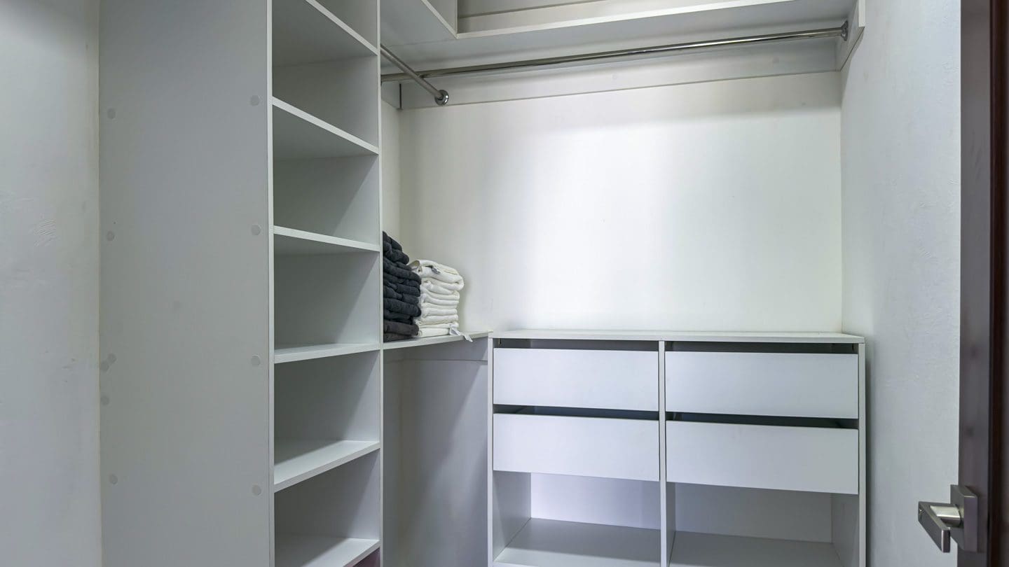 buyDRproperty Modern walk-in closet with white shelves and drawers, clean and organized. Sosua Real Estate