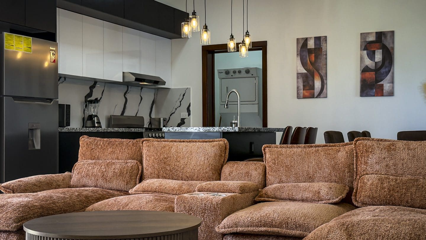 buyDRproperty Modern kitchen and living area with brown sofa, part of a 3BR Villa in Sosua Ocean Village. Sosua Real Estate