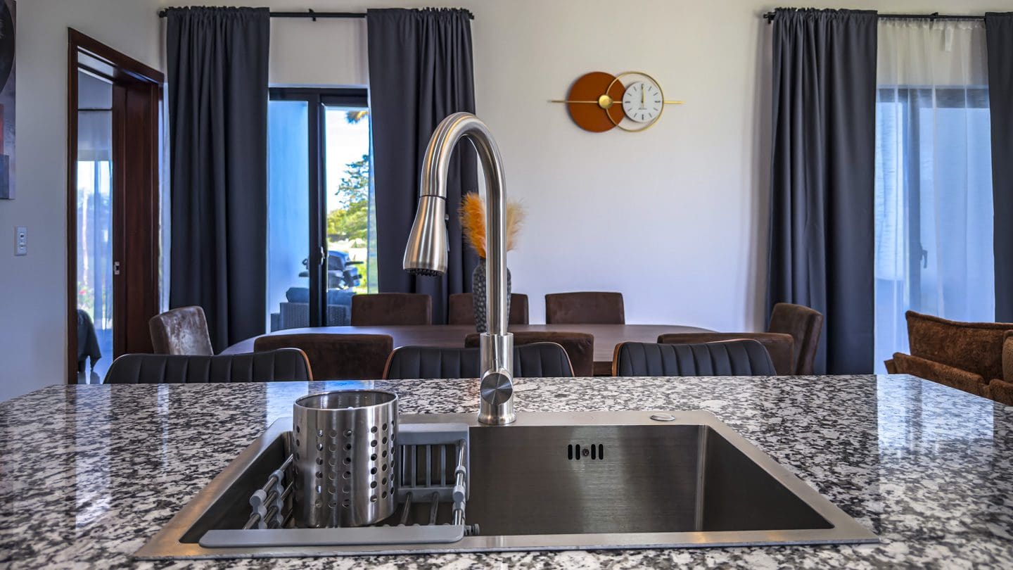 buyDRproperty Modern kitchen with stainless steel sink and granite countertop in a villa. Sosua Real Estate