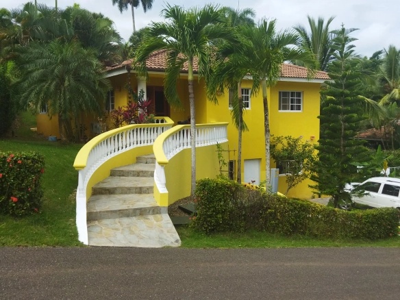 buyDRproperty Charming yellow villa with curved staircase and palm trees. Sosua Real Estate