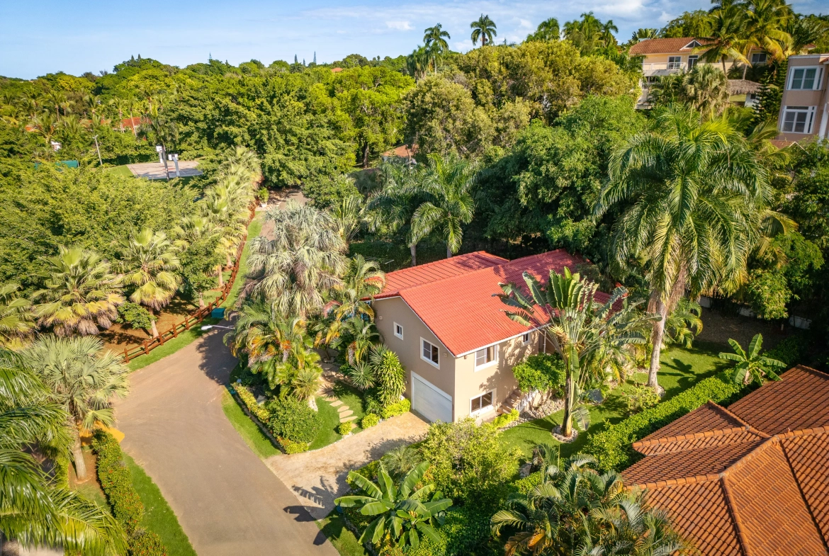 buyDRproperty Aerial view of a 3-bedroom villa with a red roof and garage surrounded by tropical trees Sosua Real Estate