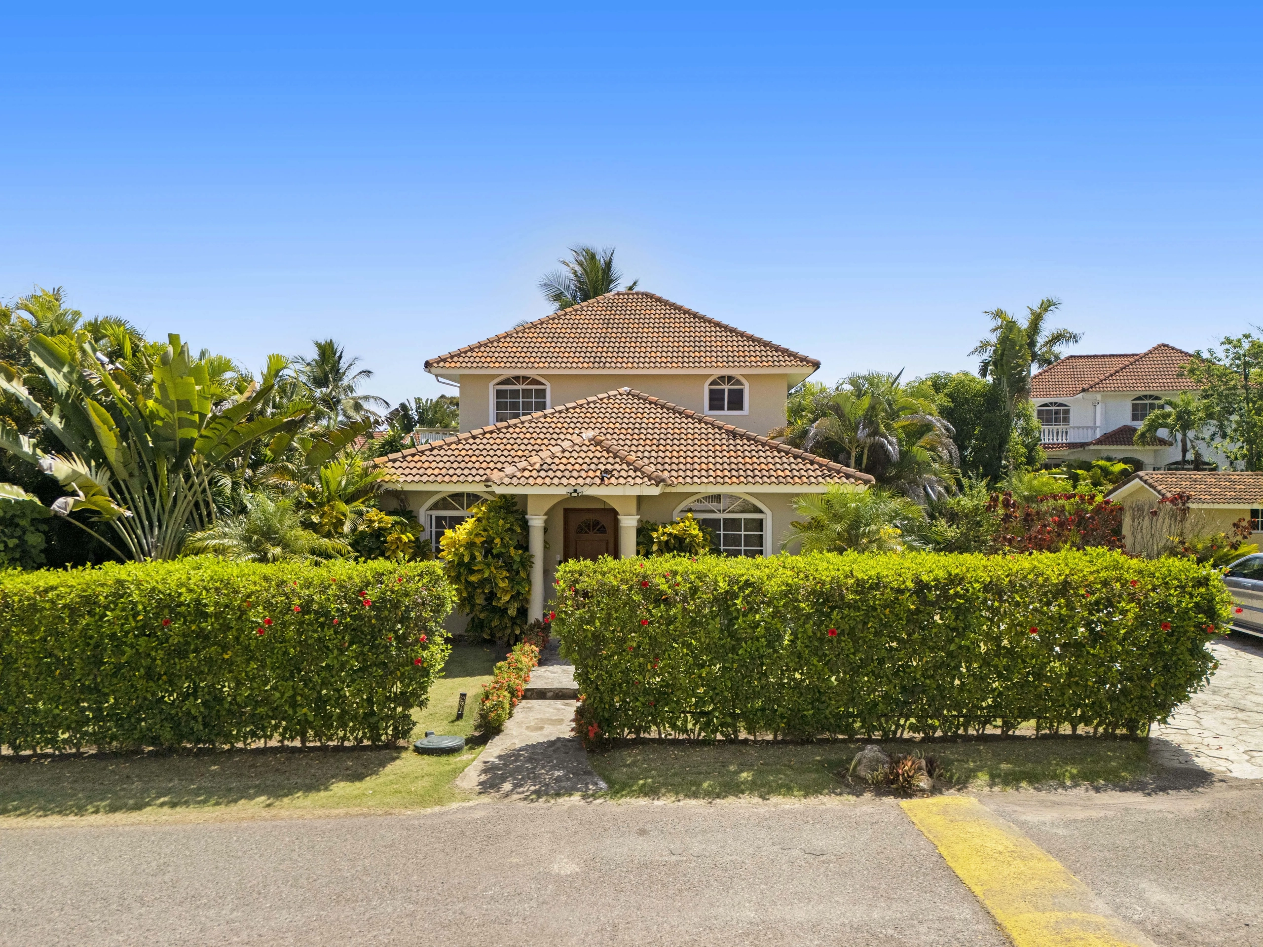 buyDRproperty Beautiful villa in Hispaniola Residencial with tile roof and lush landscaping. Sosua Real Estate