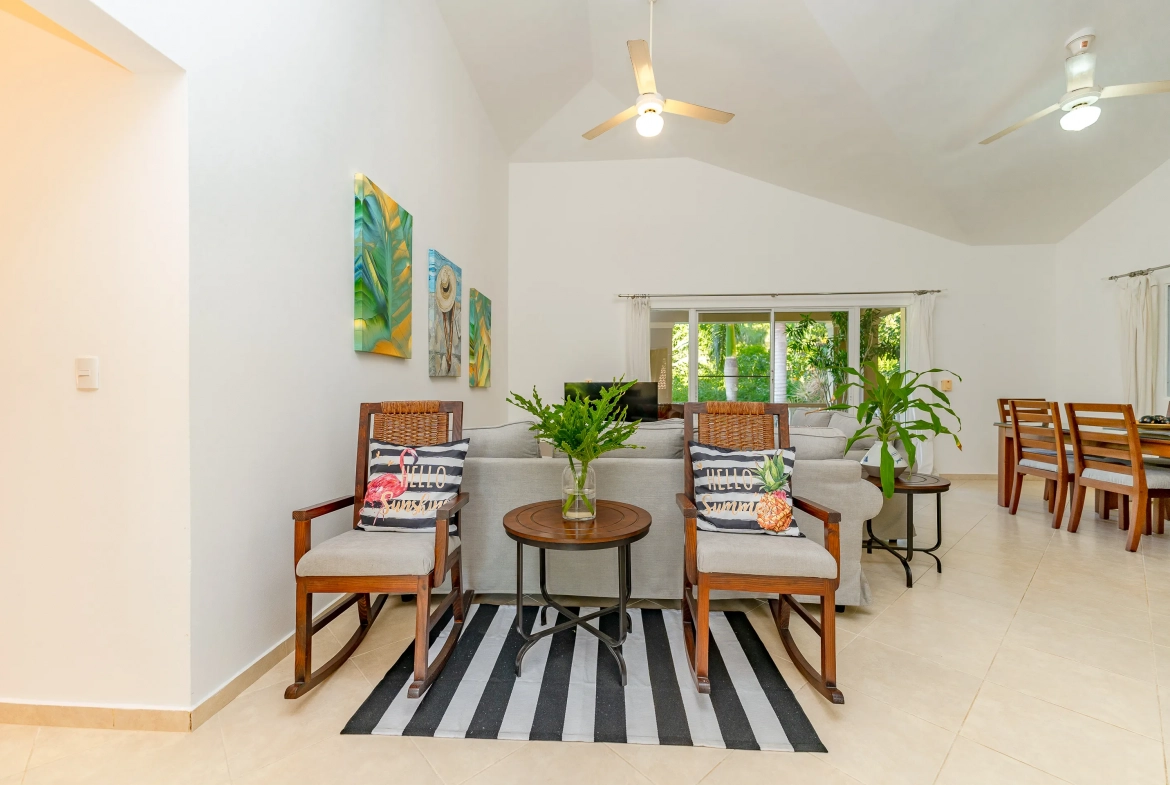 buyDRproperty Living room of a 3-bedroom villa with rocking chairs, art, and a striped rug. Sosua Real Estate