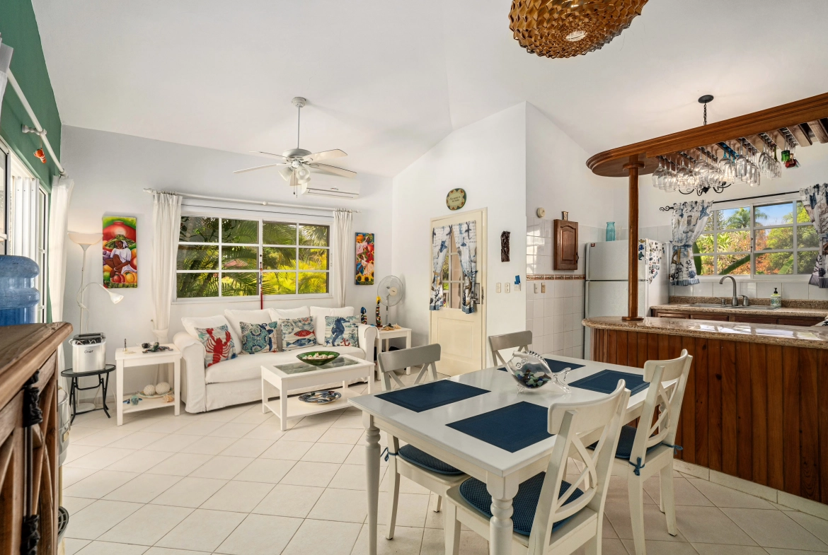 buyDRproperty Charming living and dining area in a Sosua villa with white furniture and colorful accents. Sosua Real Estate