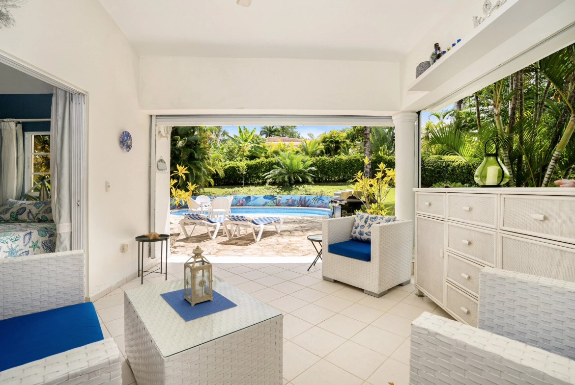 buyDRproperty Charming villa living space with pool view, white wicker furniture Sosua Real Estate